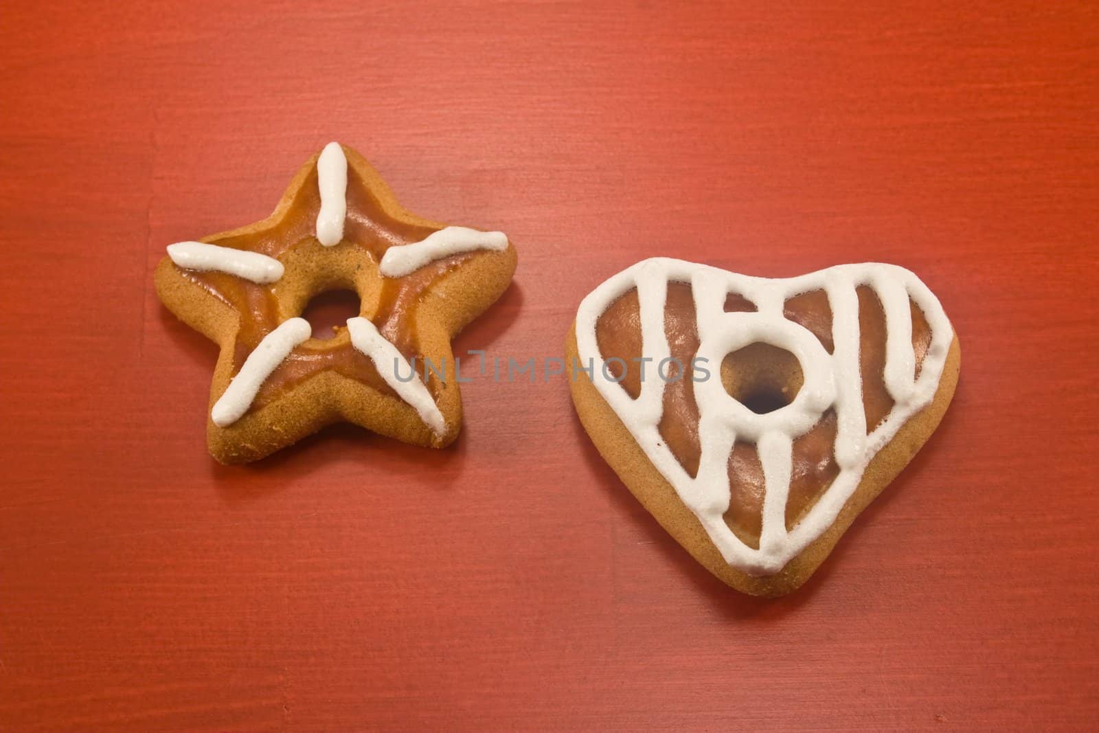 Decorated star and heart cookies on red background
