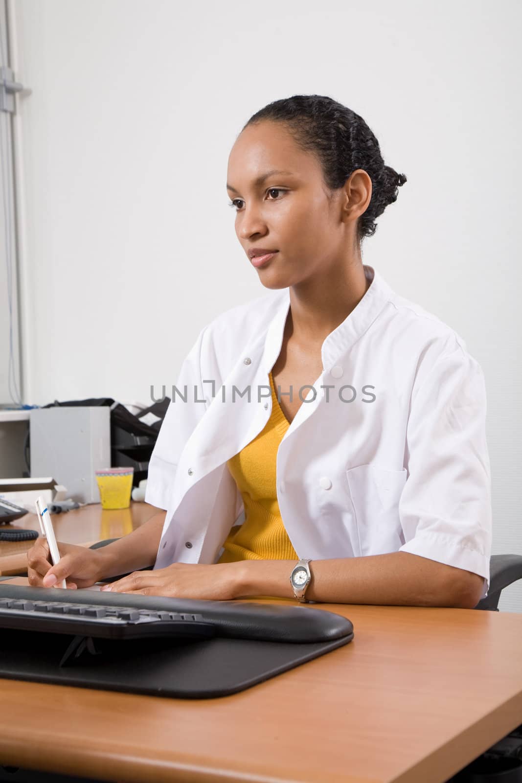 Doctor in uniform sitting in her office and working behind the computer