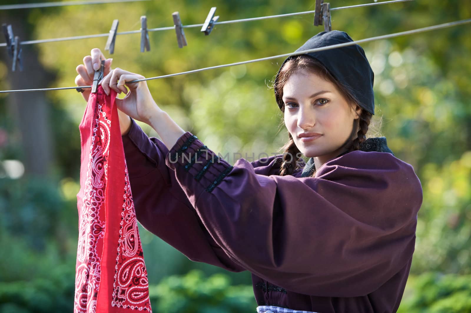 Pretty farmer girl hanging the laundry outdoors to dry