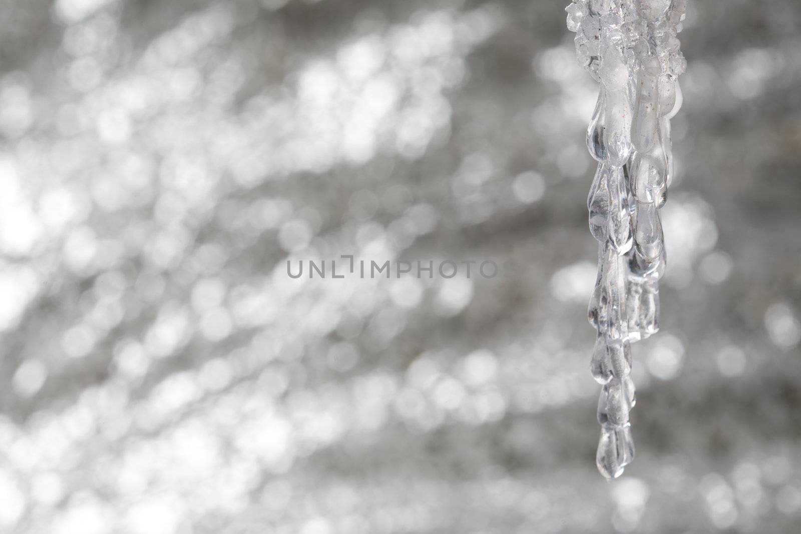 Shining icicle on glittering silver background for christmas