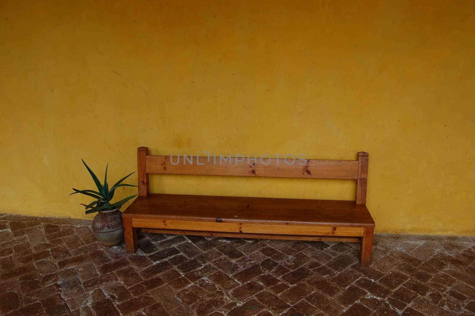 Bench against a yellow wall and tile floor in Chiapas Convent