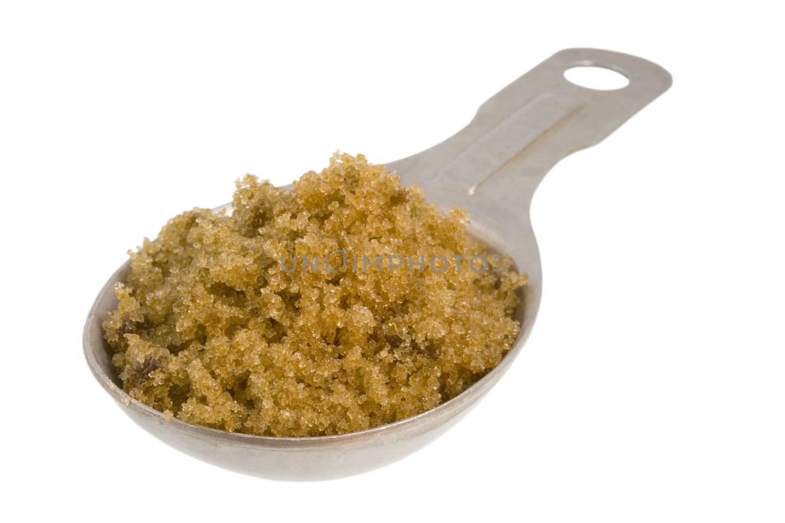 Measuring tablespoon of brown sugar on white