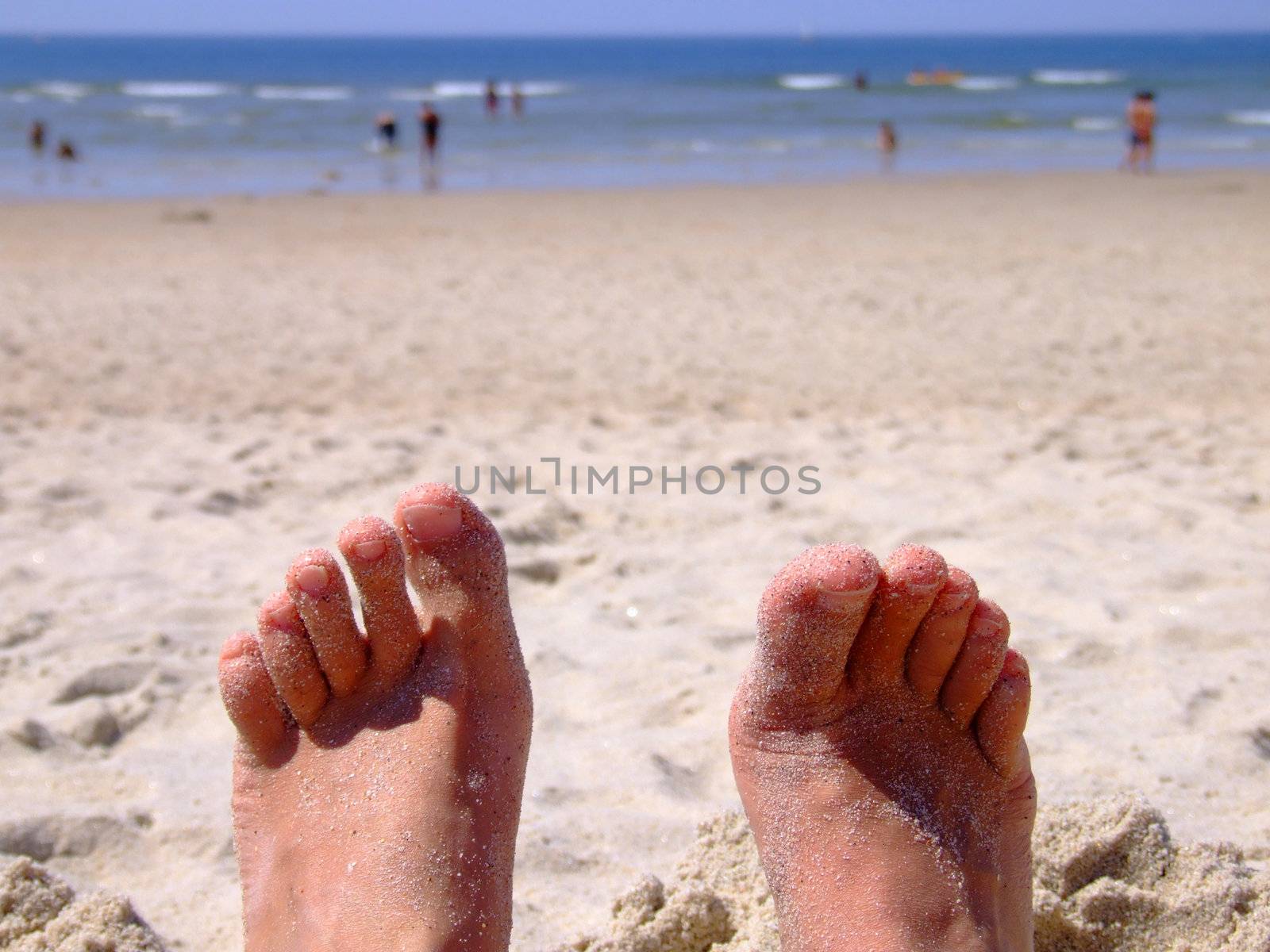 Sandy feet of someone relaxing in the beach