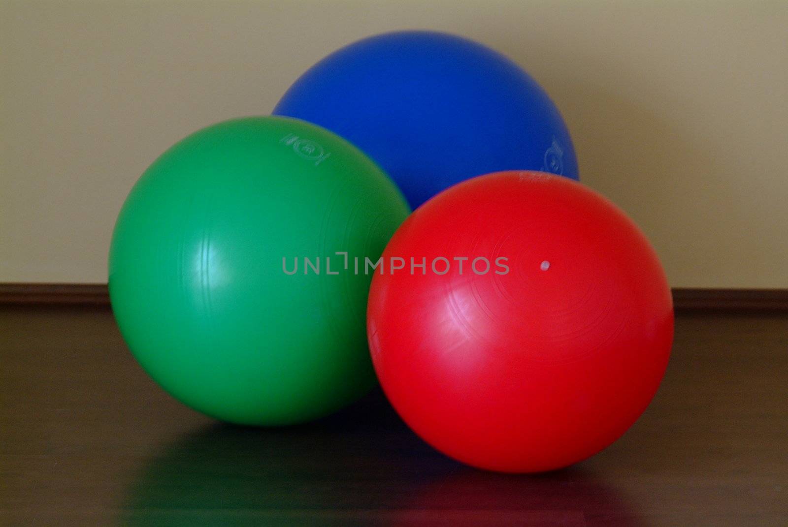 gym balls in blue, red and green on the floor