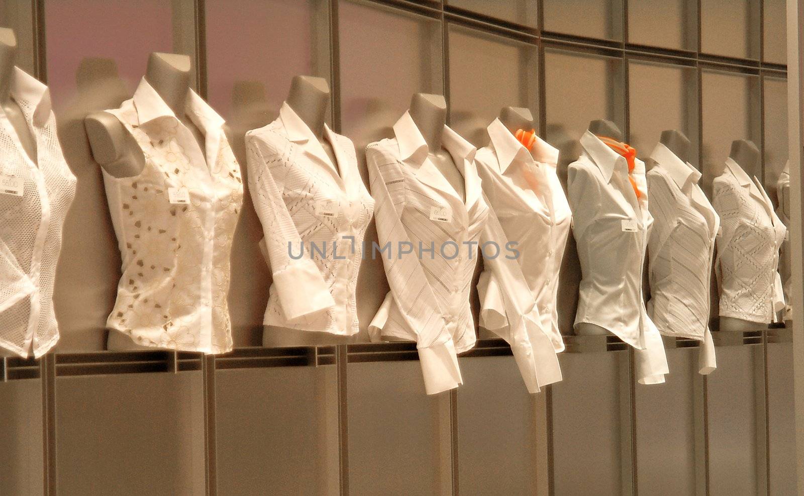 eight white blouses in shopwindow