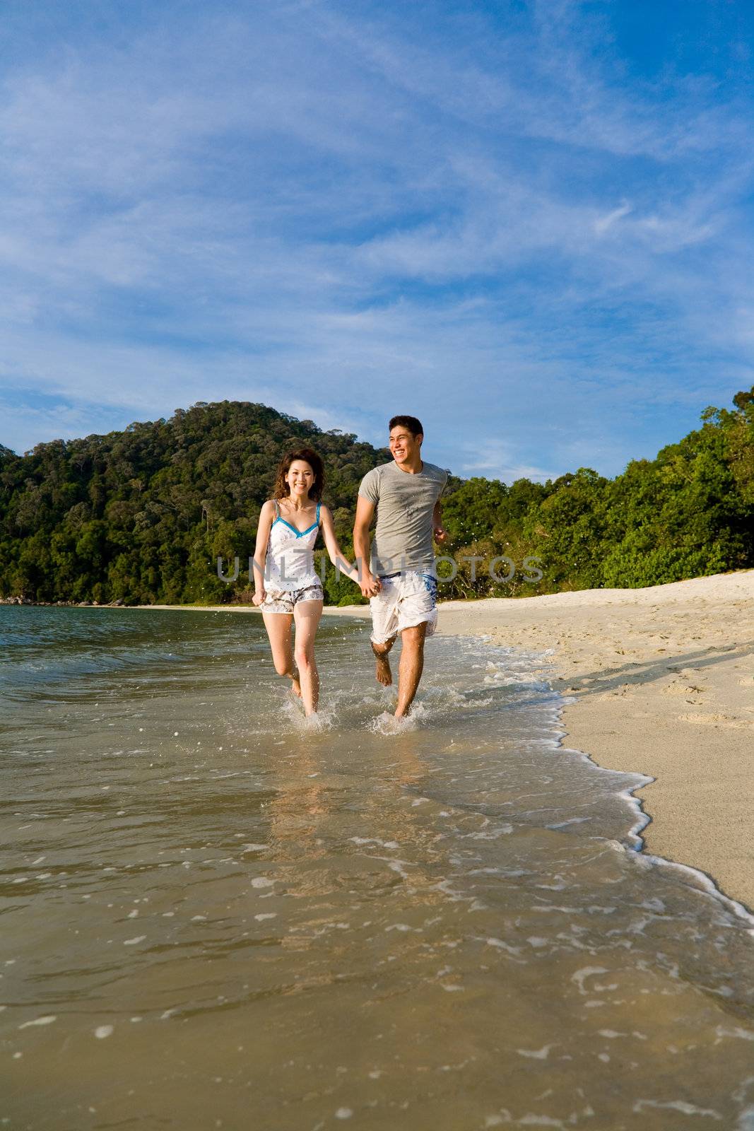 loving young couple running on the beautiful tropical beach