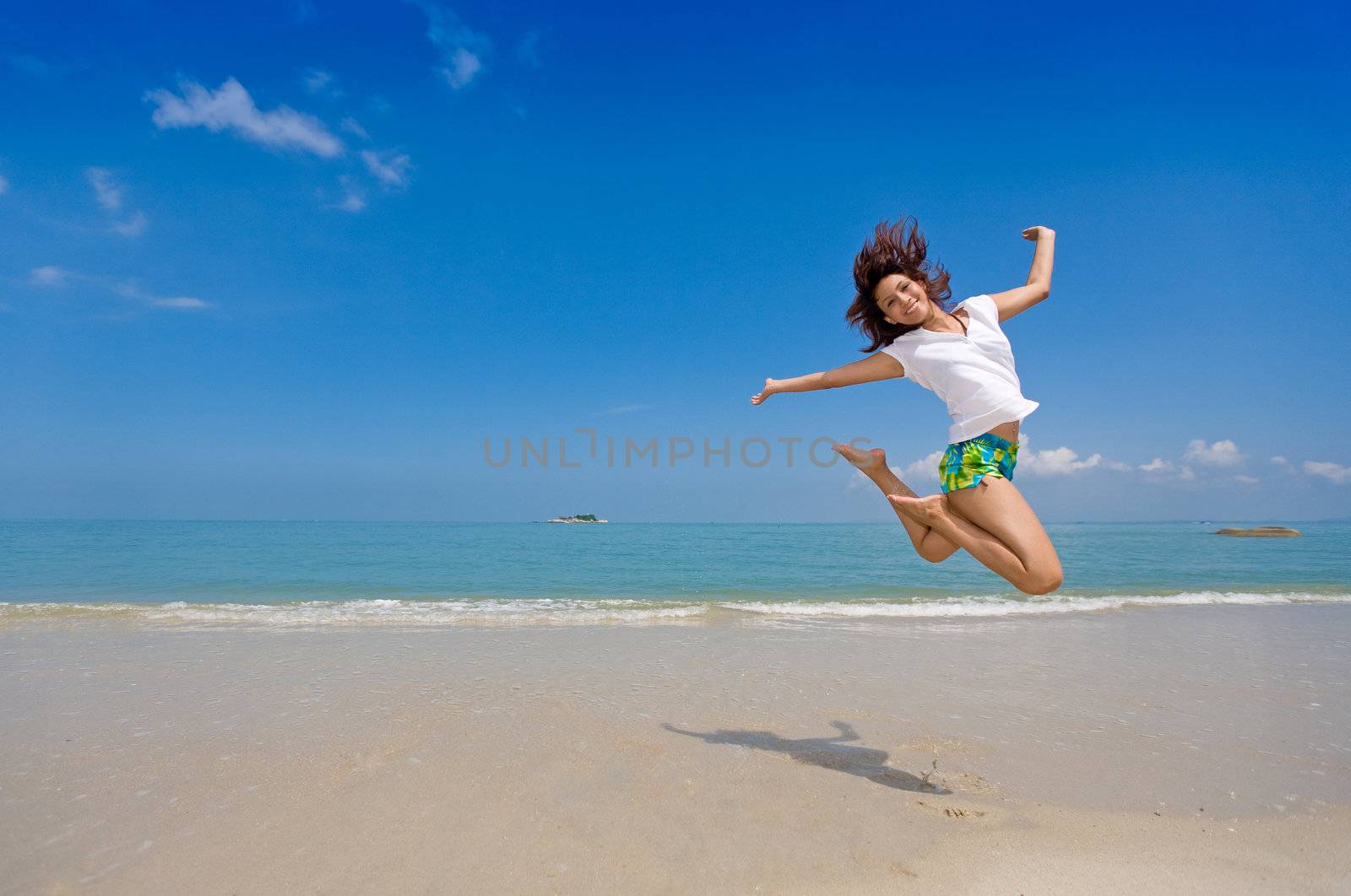 young beautiful girl jump gracefully at the beach