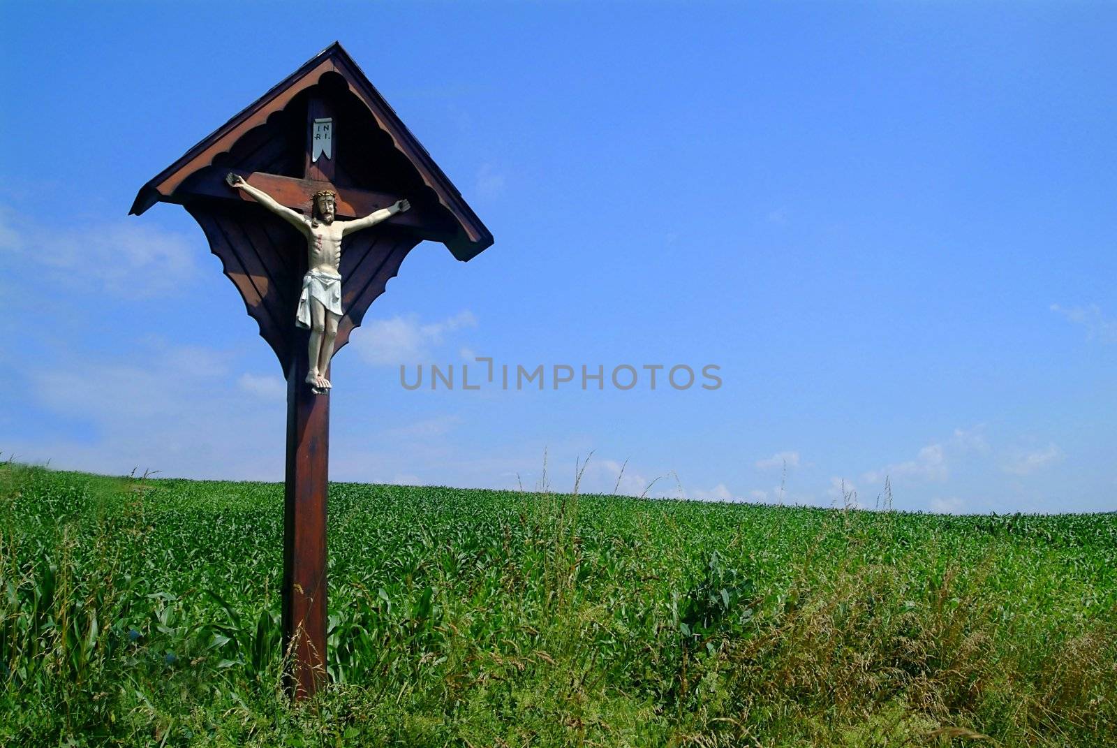 cross and jesus at meadow with blue sky