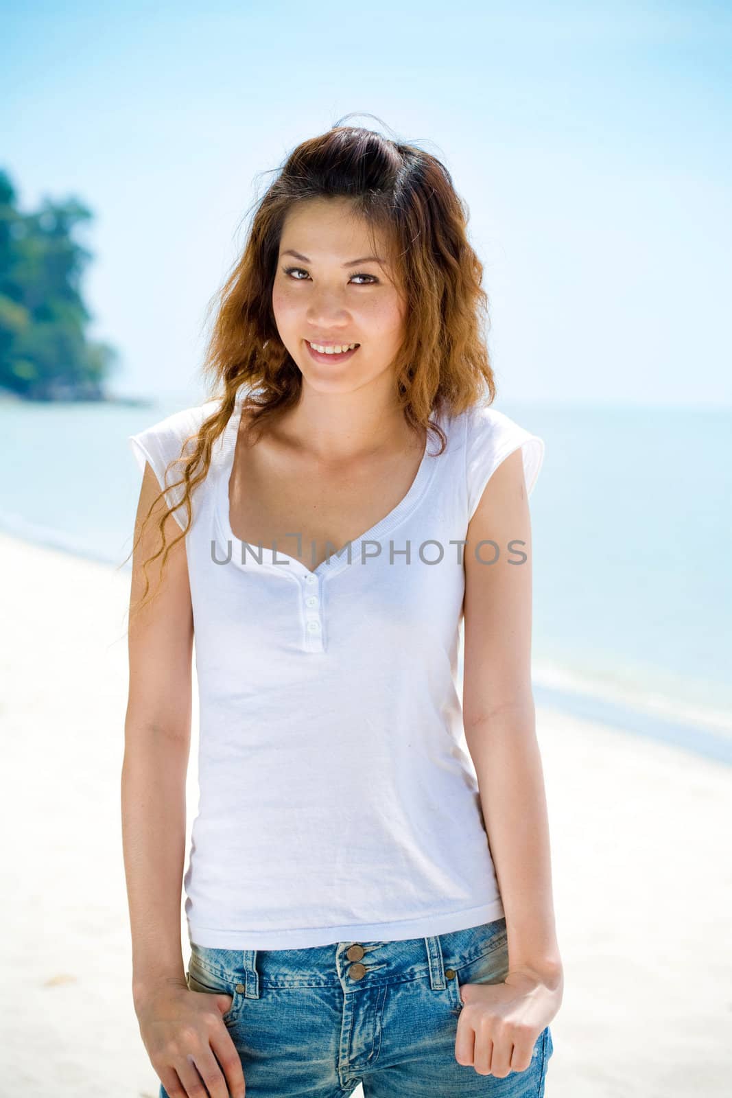 young woman smiles by the beach by eyedear