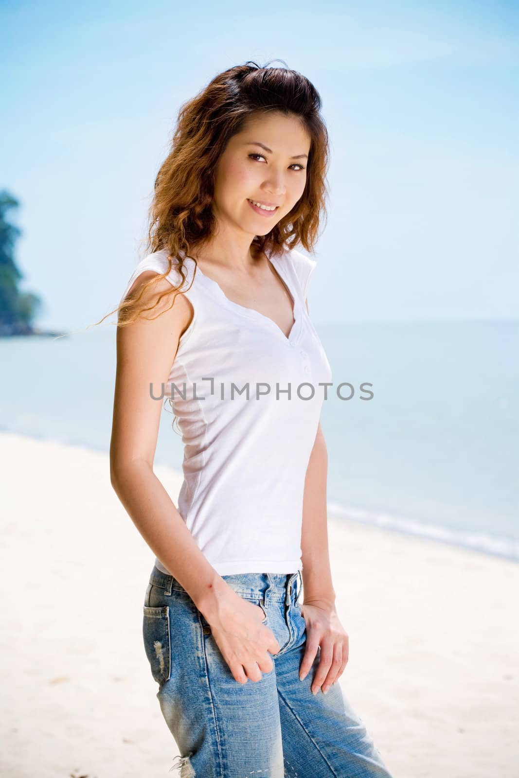 young woman looking happy and relax at the beach in casual jeans wear