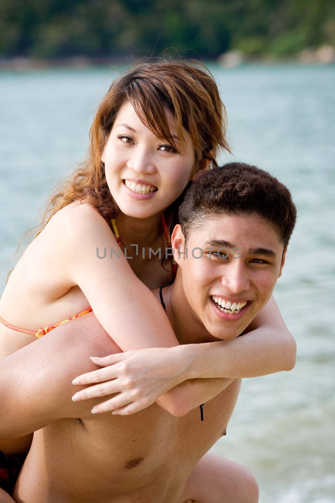 happy young couple having fun on the beach by eyedear