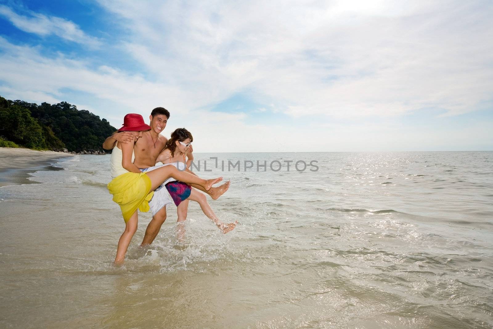 3 friends playing with sea water at the beach