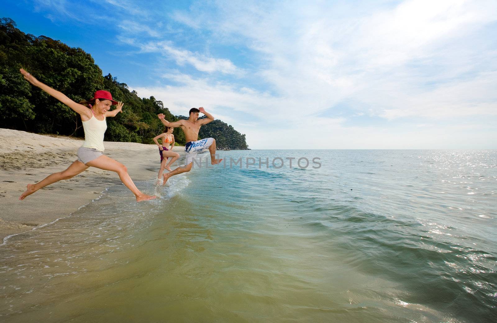 a group of boy and girl friends jumping into sea excitedly