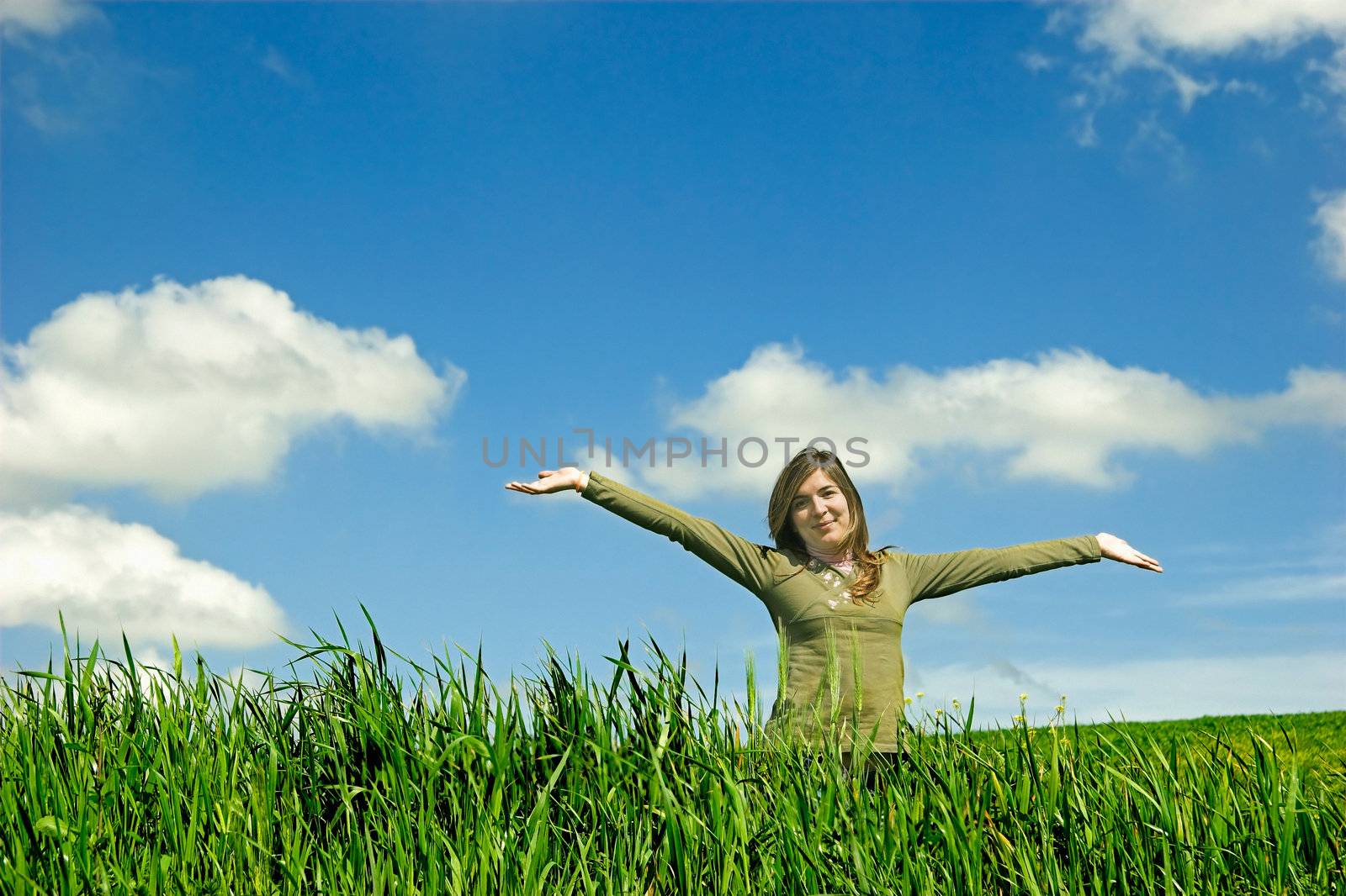 Happy young with open arm in the field