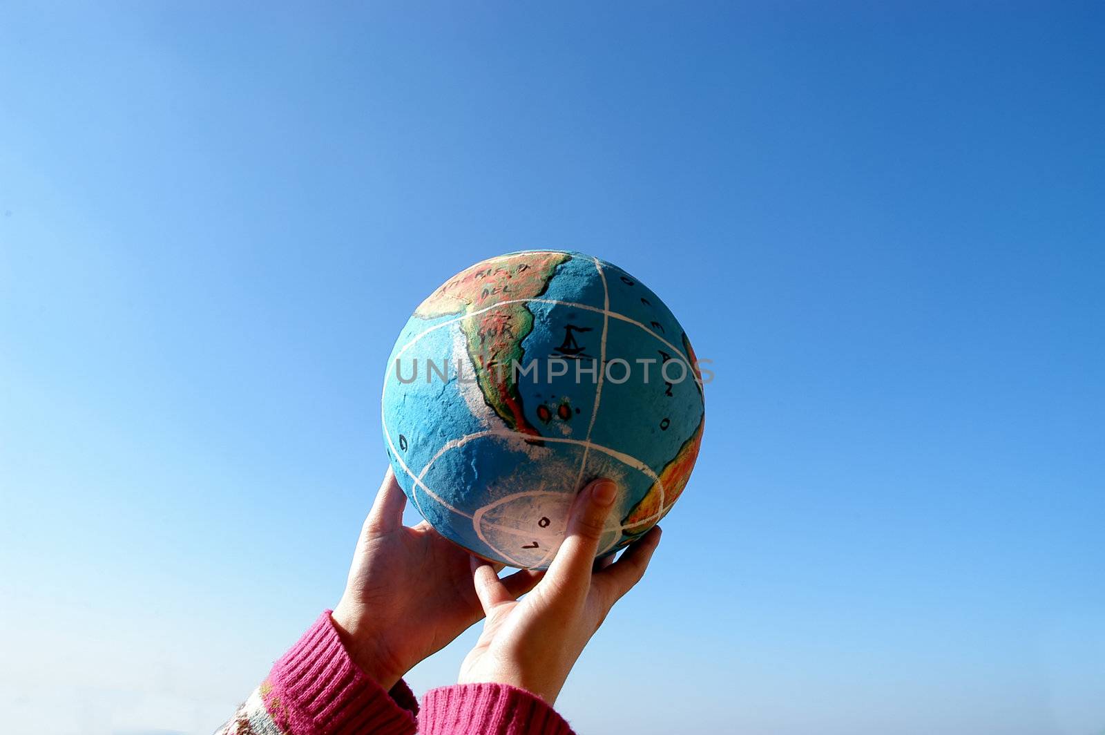 small globe in a woman hands and the sky