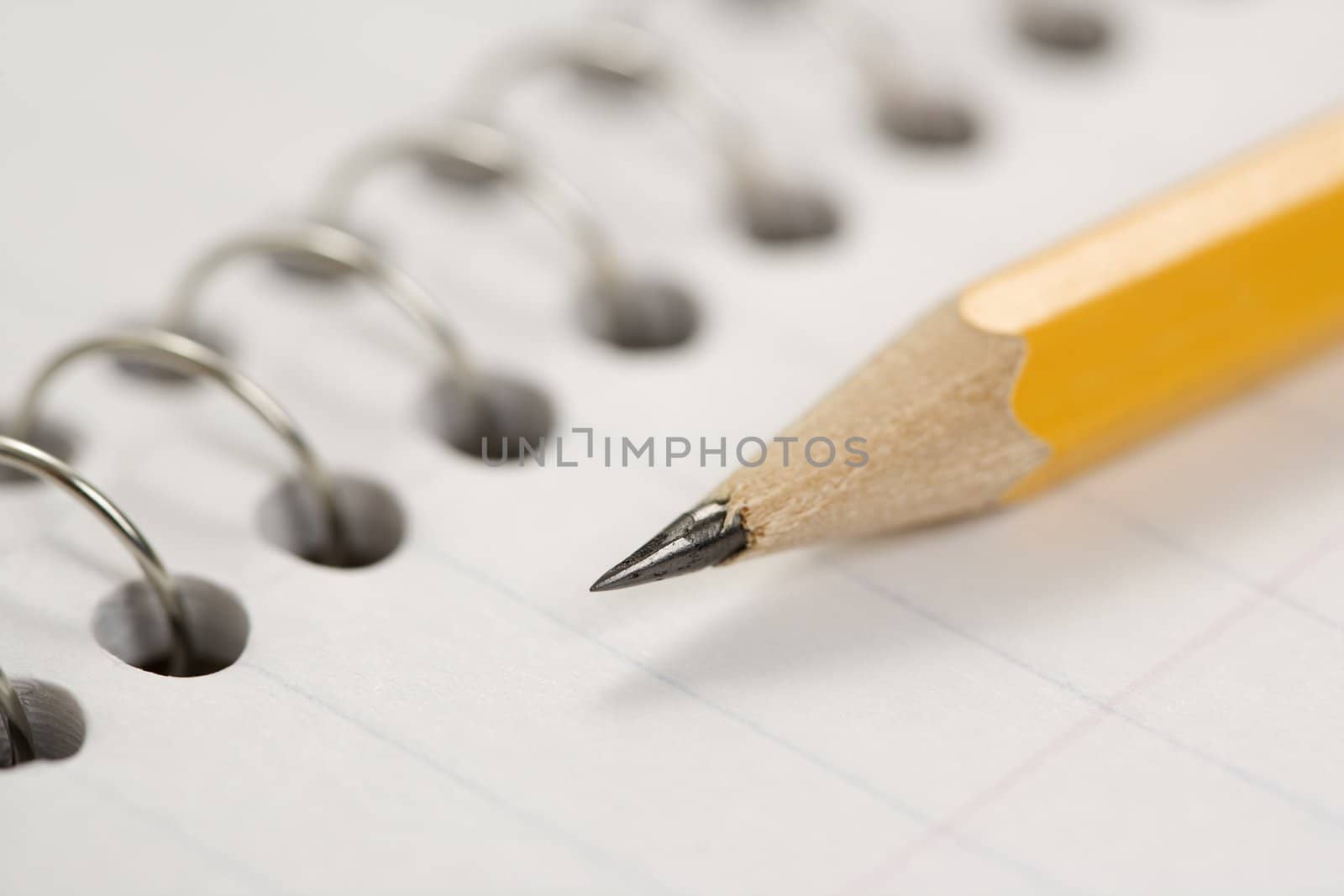 Close up of pencil on top of spiral bound notebook.