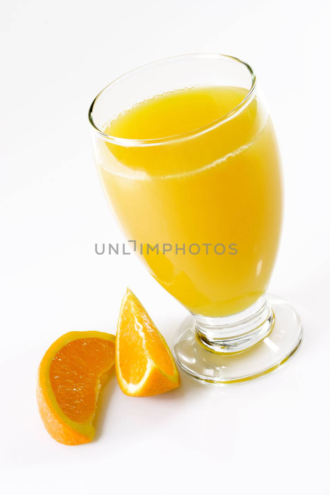 Glass of orange juice with garnish on light background