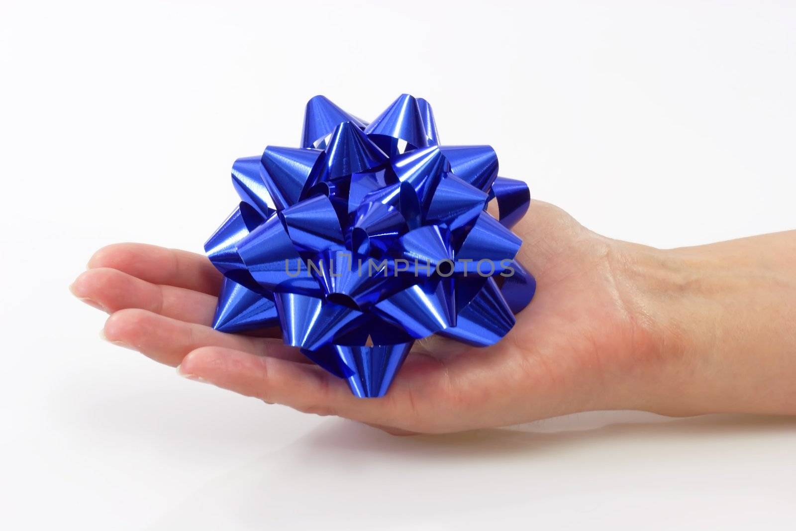 Close up of a blue bow in a hand on light background