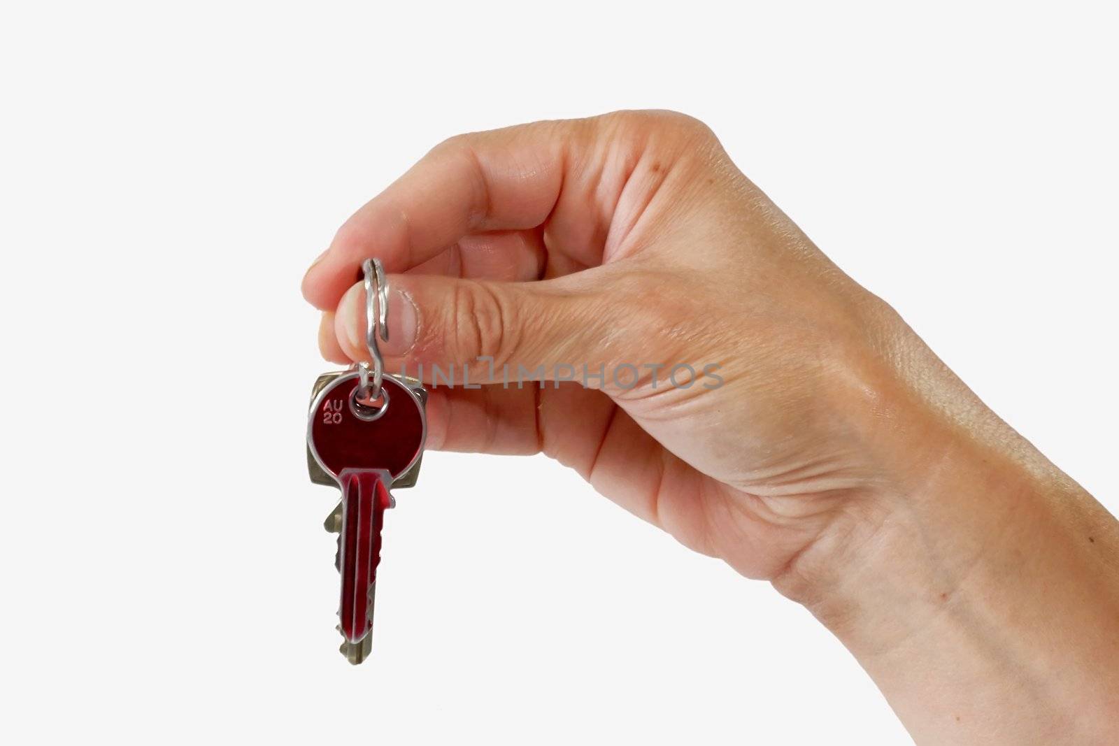 Close up of a key in a female hand on light background