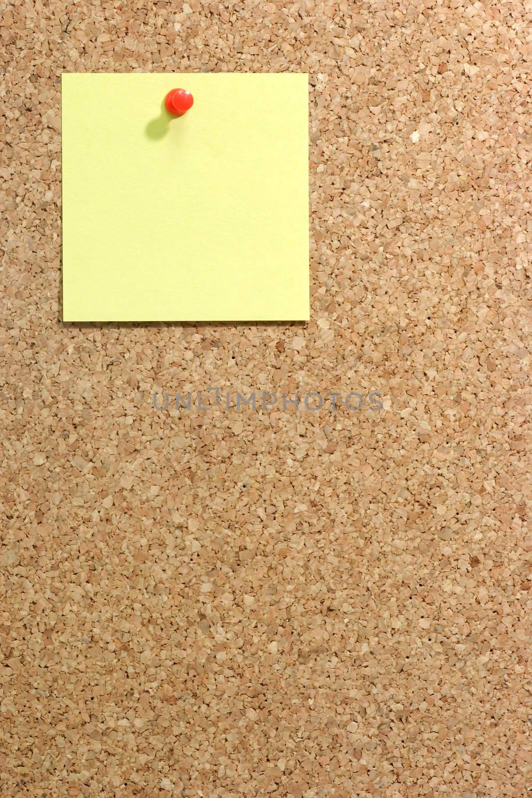  Colorful blank post it note affixed to the corkboard.
