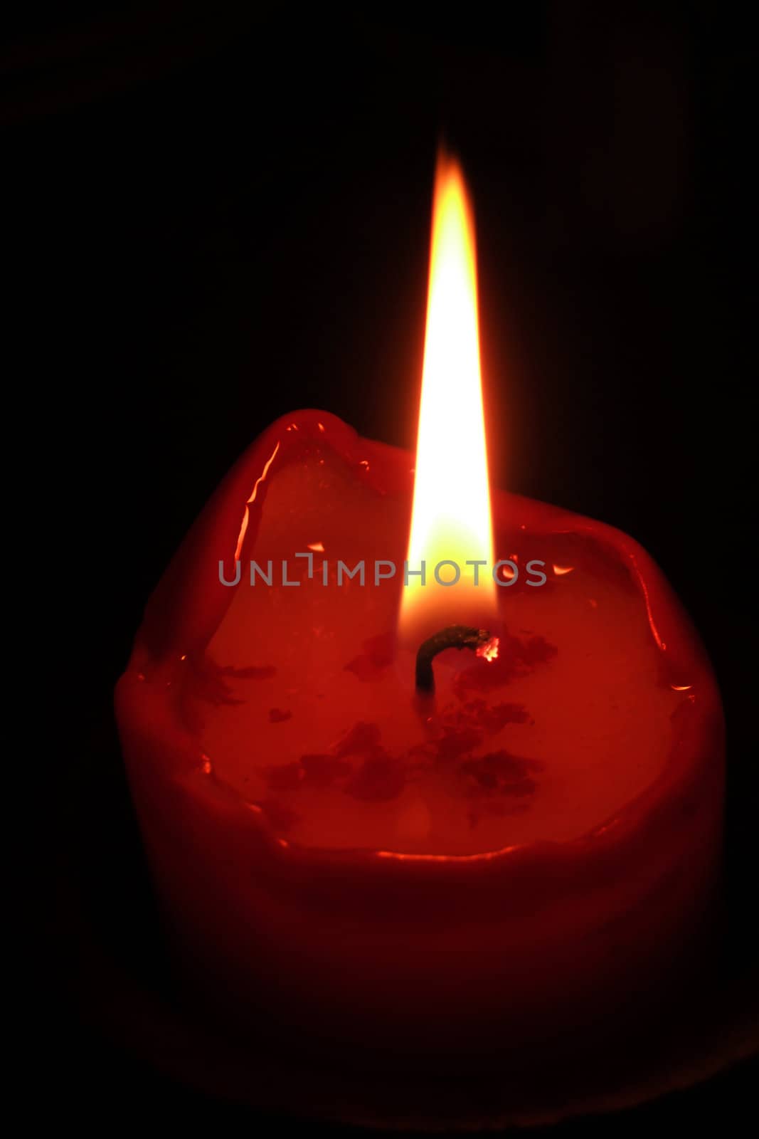 Burning candle, black background by ystock