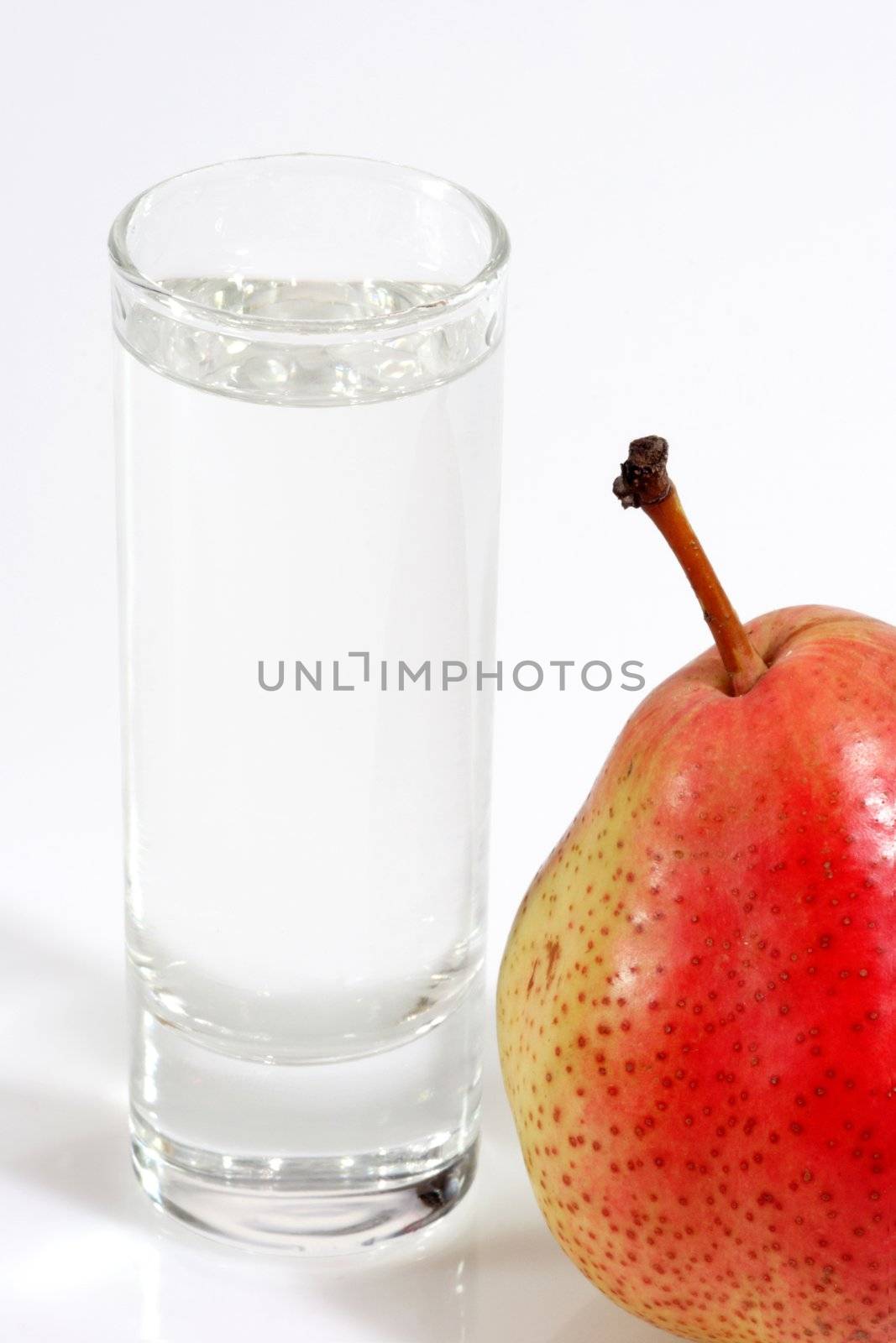 Glass of pear brandy on the bright background