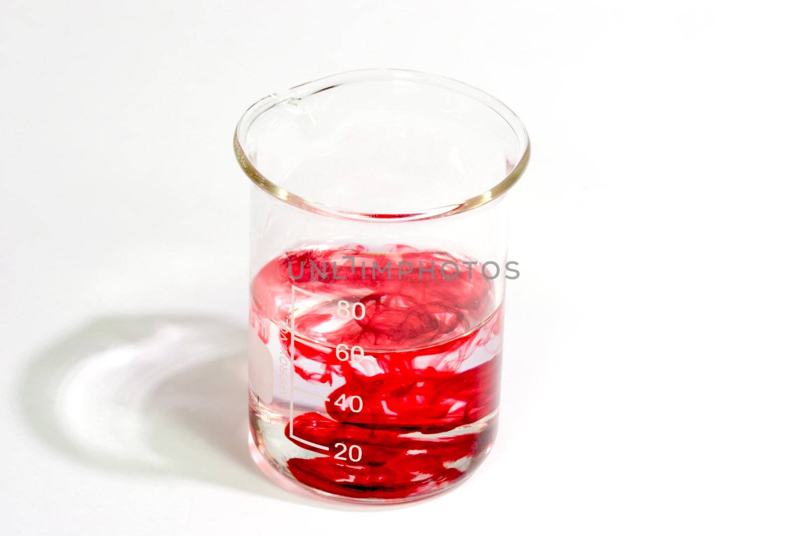 Graduated beaker with red fluid on bright background