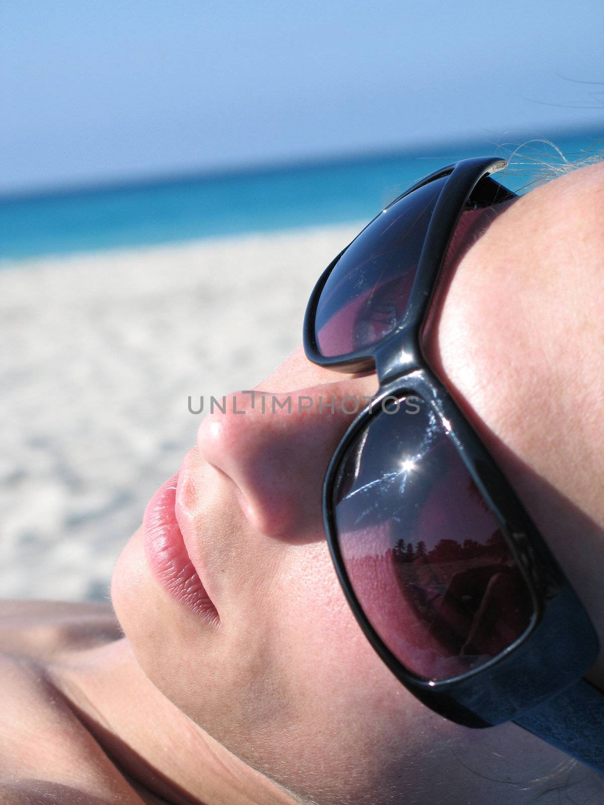 female with shades on the beach by mmm