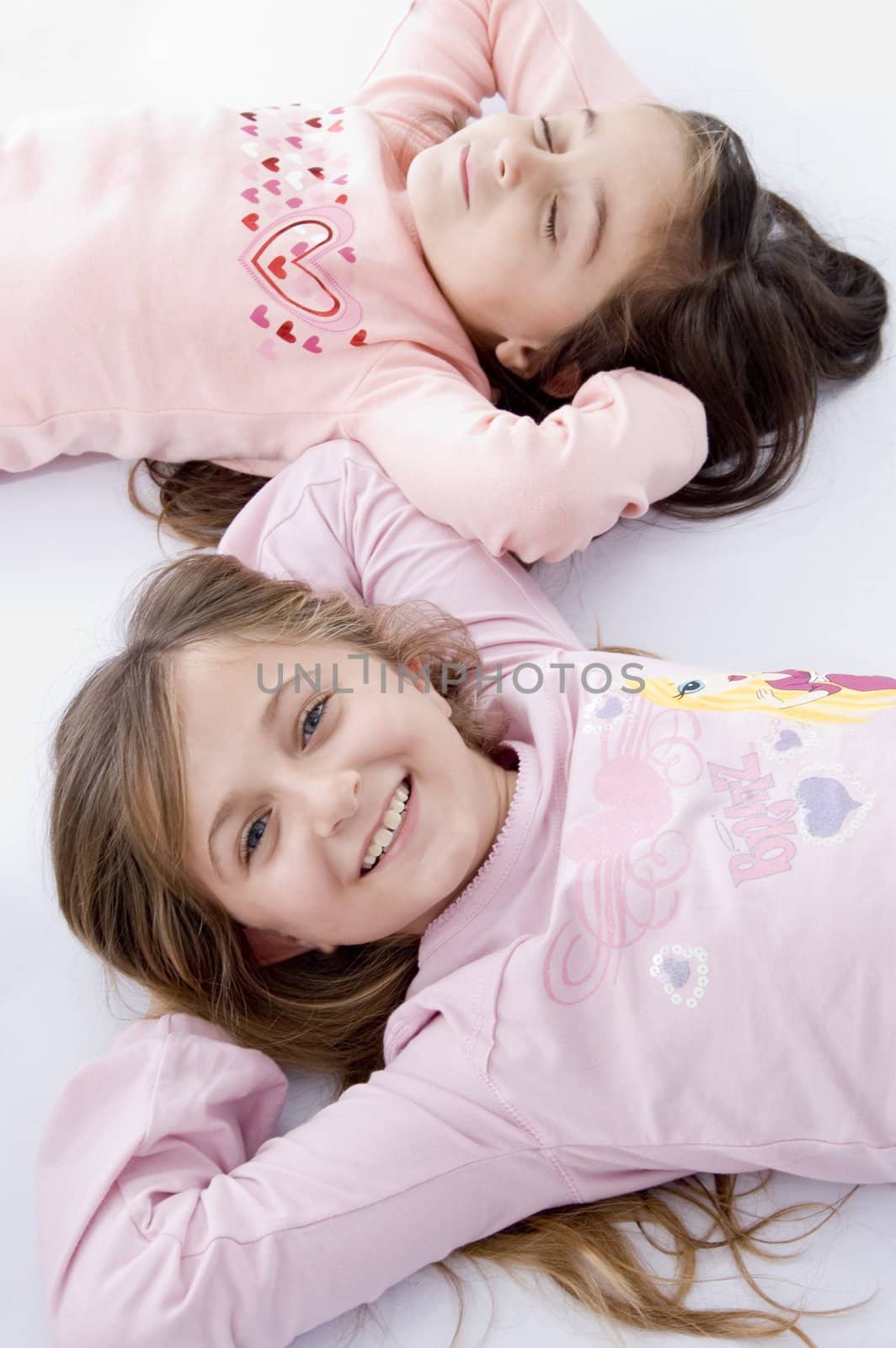 sweet little laying sisters on an isolated white background