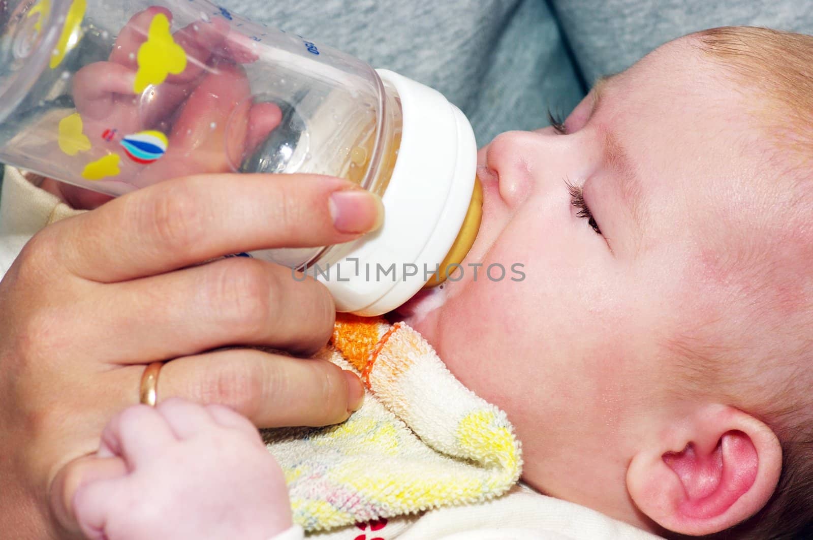 Newborn eating. Bottle of milk.