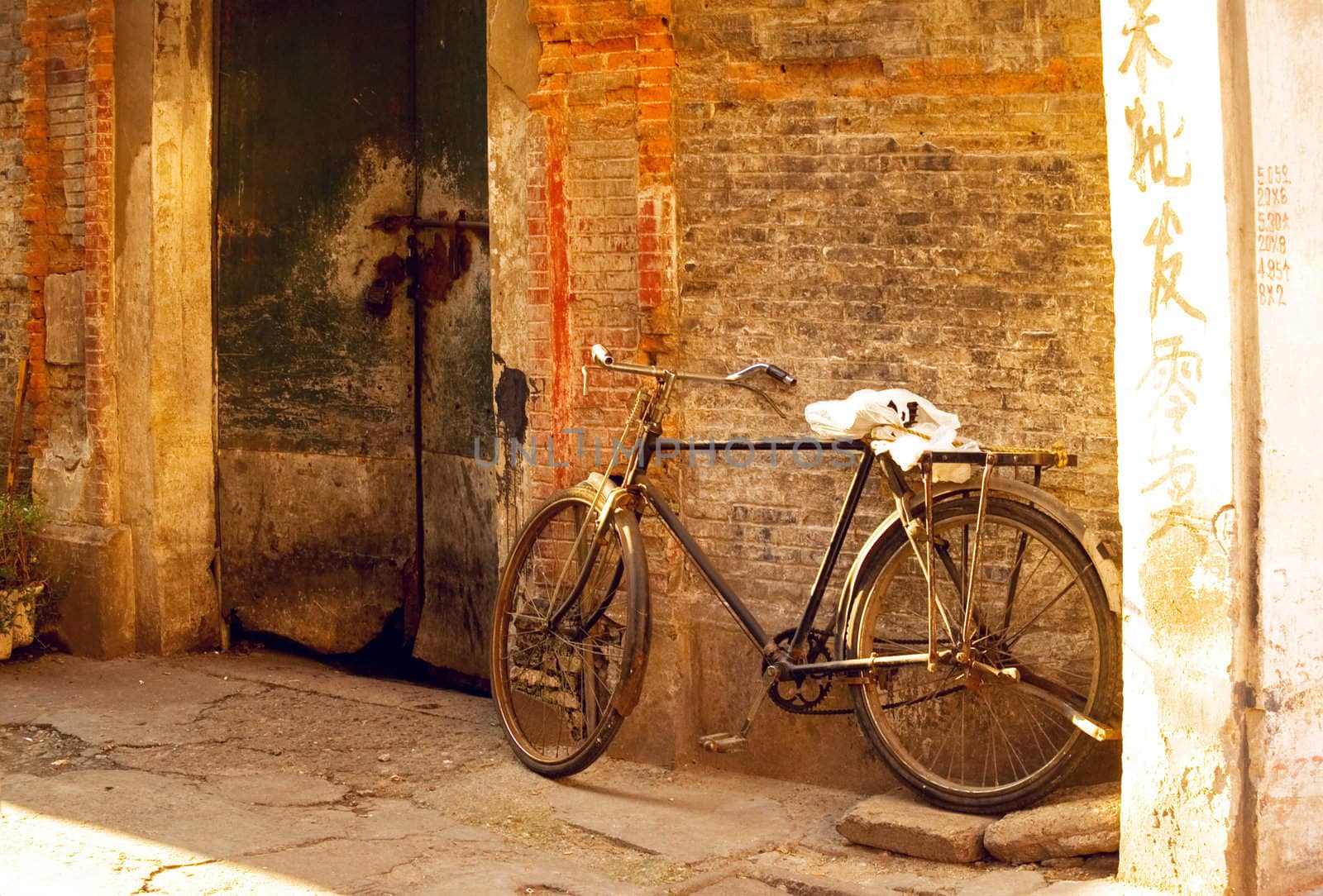 shanghai old bicycle over a brick walland old door