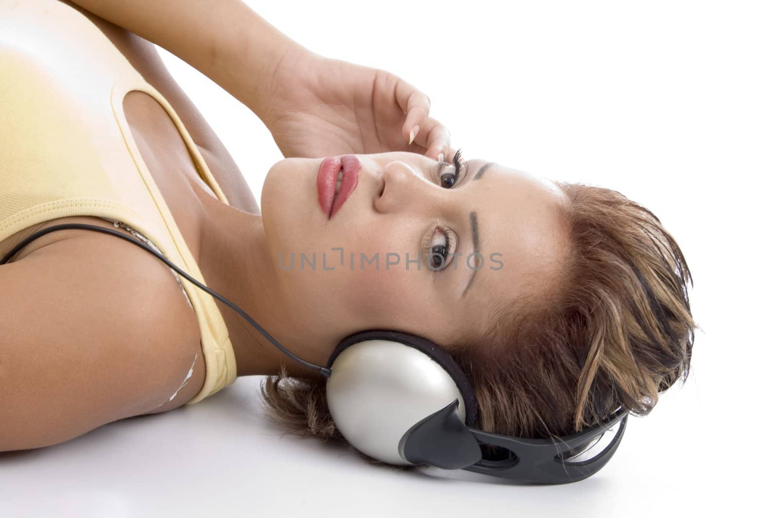 laying woman with headphone looking at you on an isolated background