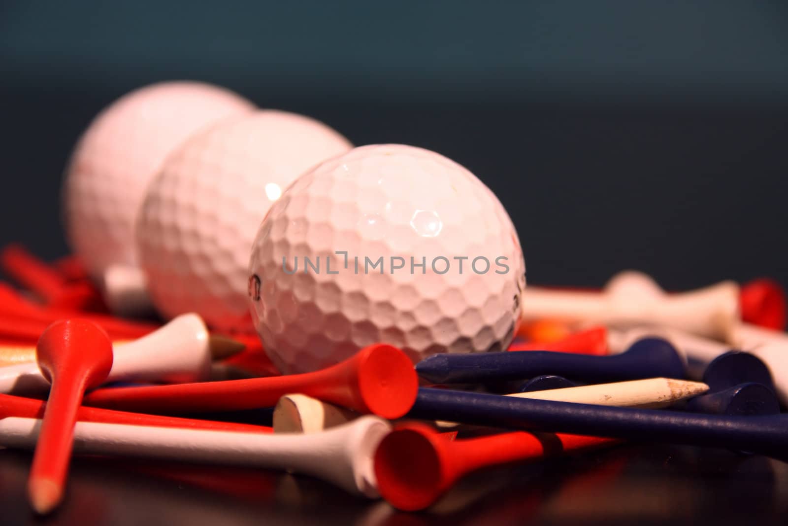 close up of golf balls and tees arranged in a line
