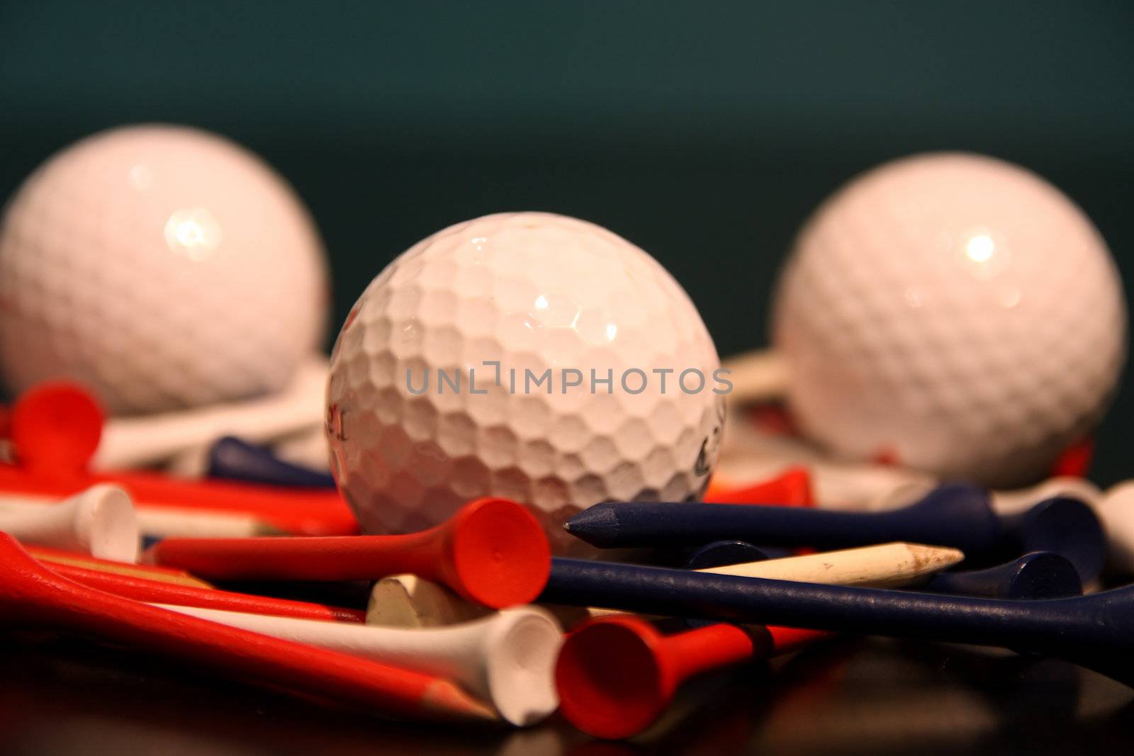 close up of golf balls and golf tees 