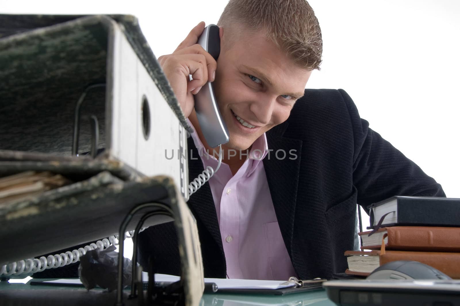 handsome smiling manager busy on phone on an isolated white background