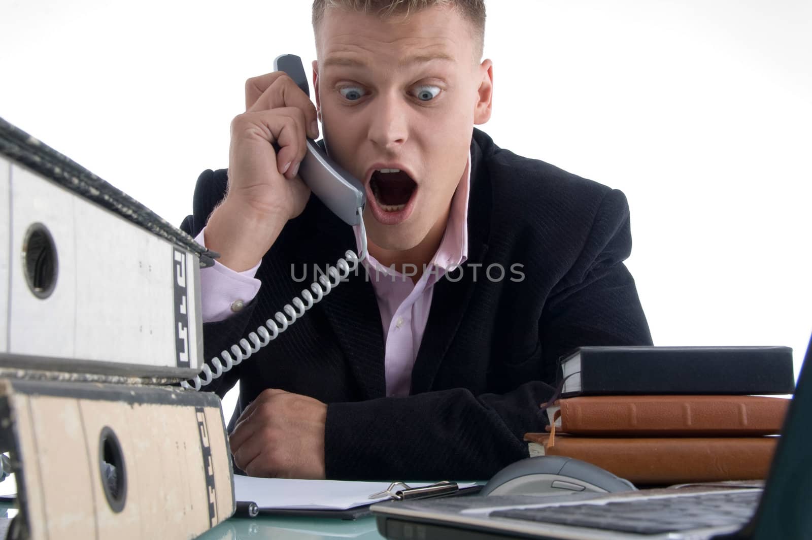 shocked businessman holding receiver  on an isolated white background