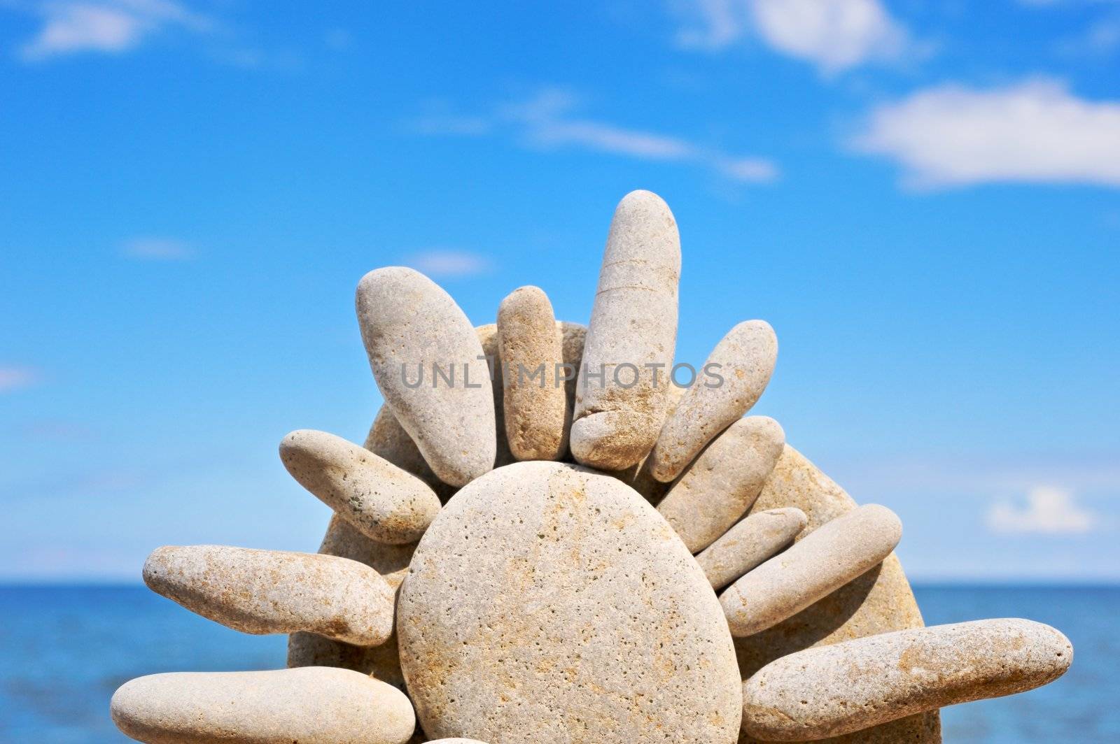 Sea pebble in the form of the sun on a beach in the summer