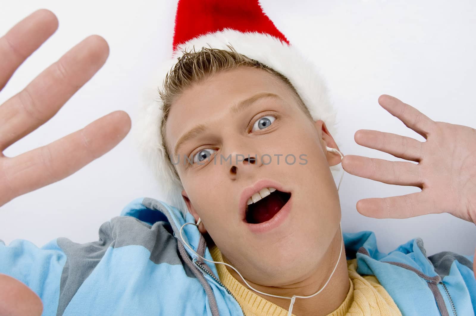 scared young man with christmas hat by imagerymajestic