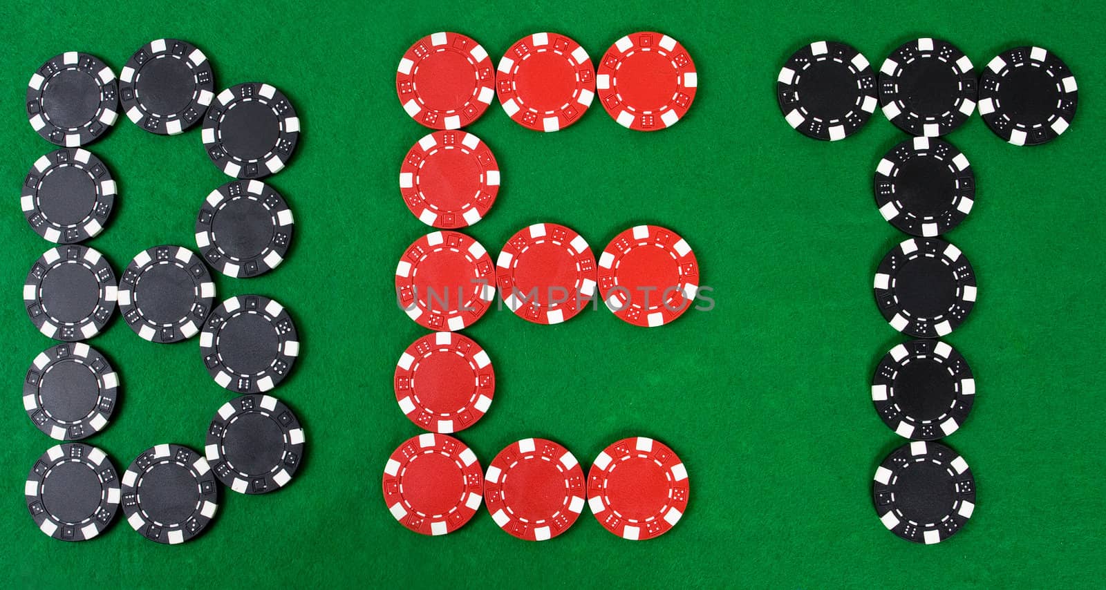 Bet - word build using red and black poker chips. Green poker table.