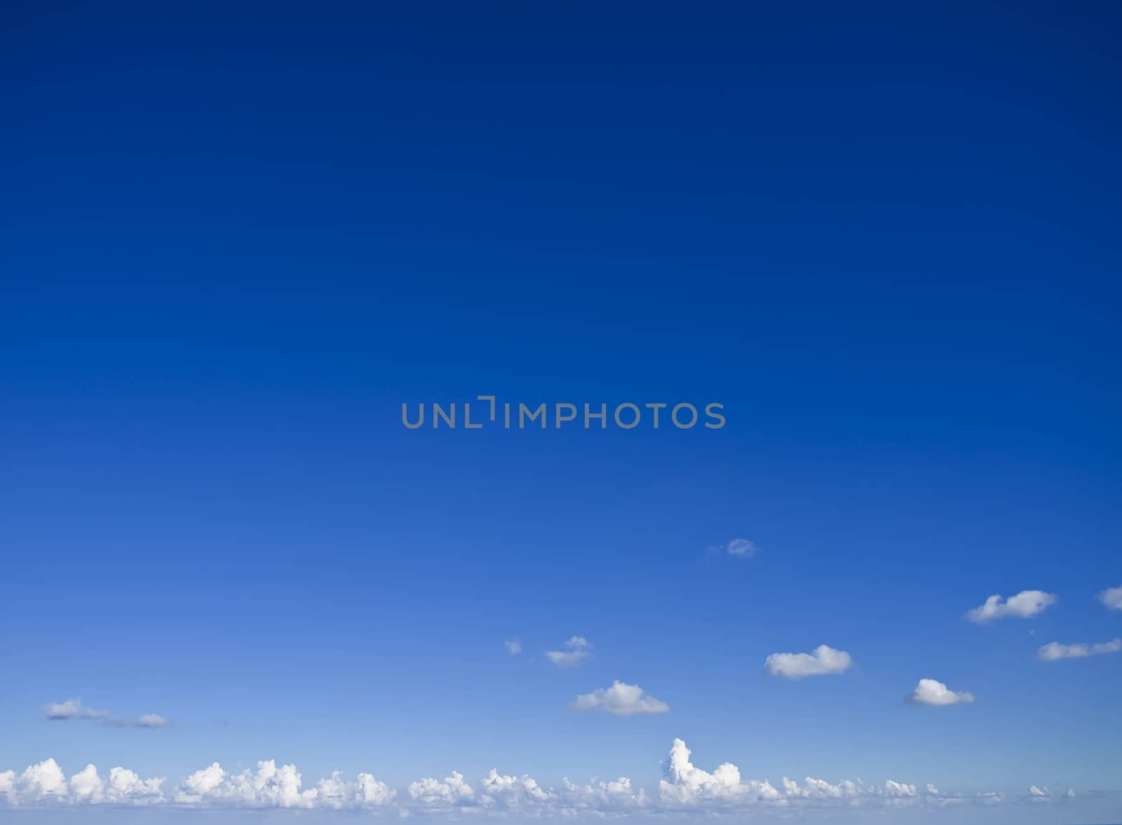 Slight cloud over a clear blue sky ideal as backdrop