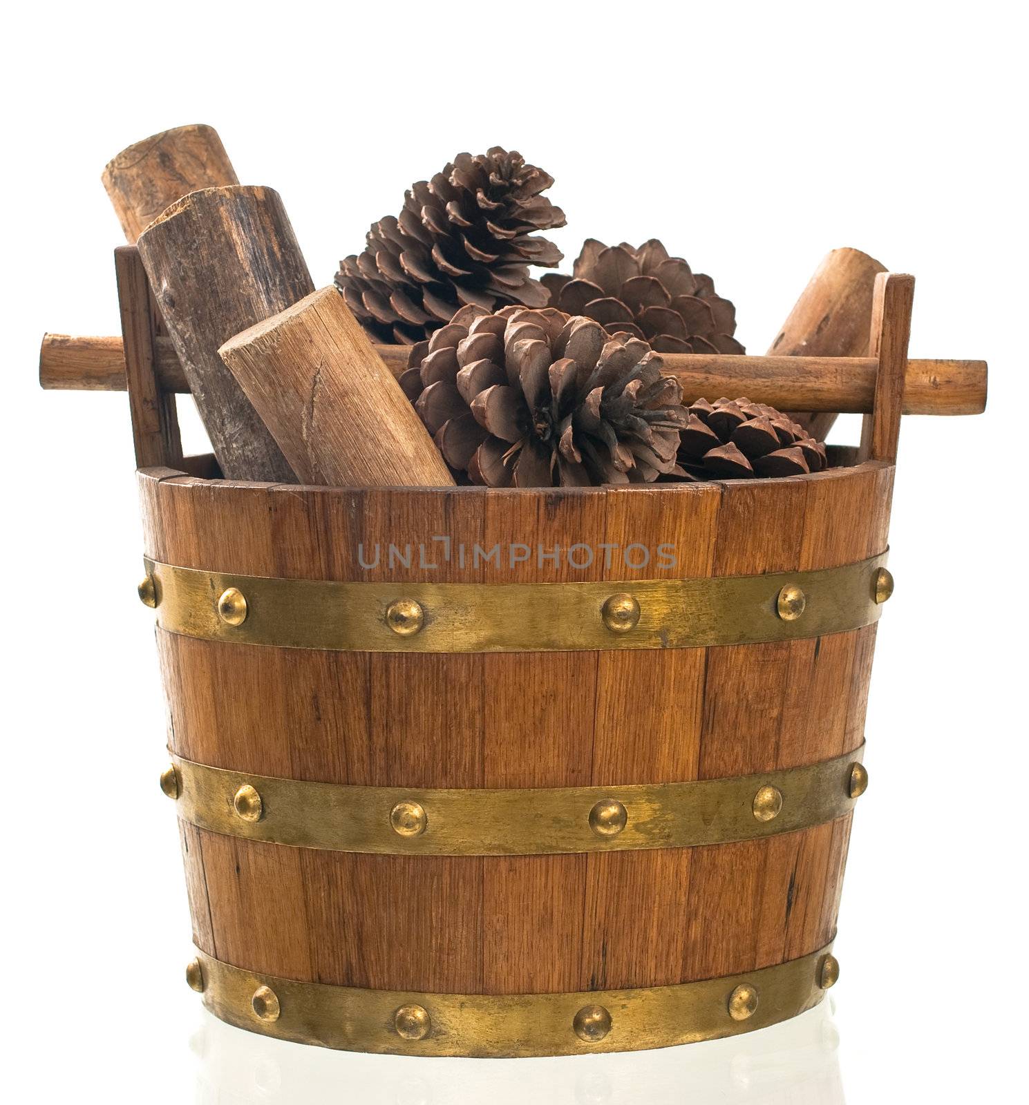 Basket with pine and wood isolated on white standing on a reflective surface.