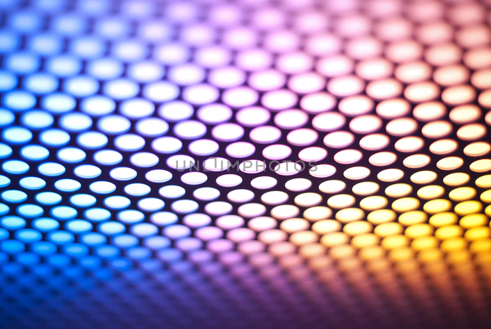A metalic reflective surface back lit by a colorful light.