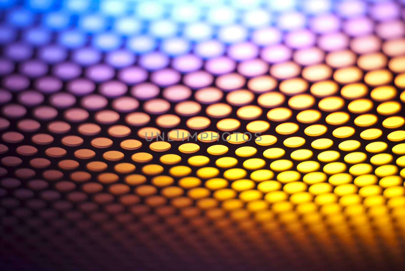 A metalic reflective surface back lit by a colorful light.