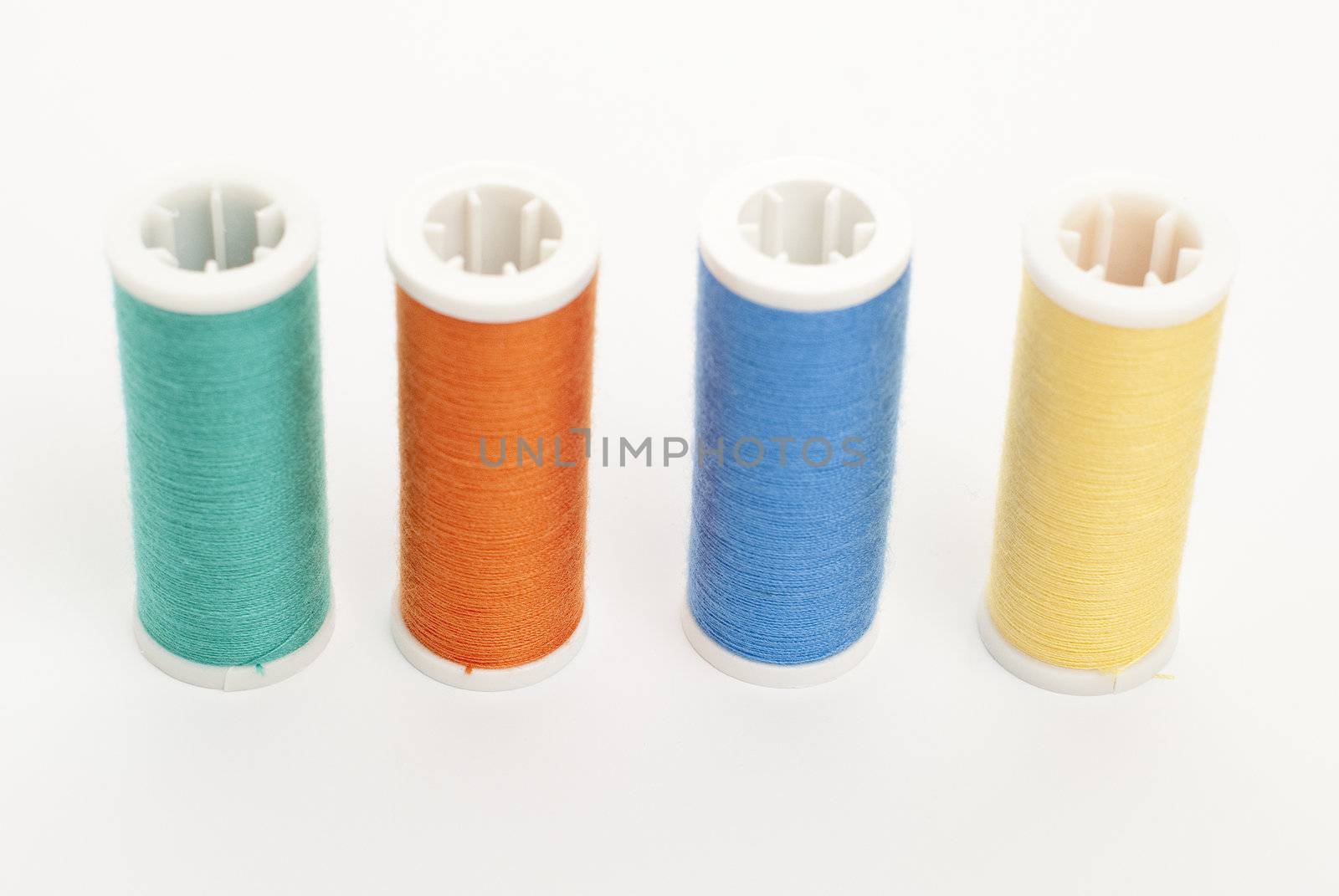 Colorful Spools of sewing thread isolated on white background.