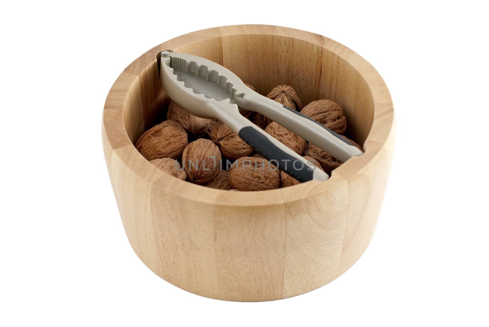 Food background, macro shot of a group of walnuts and a wood basket with a nutcracker.