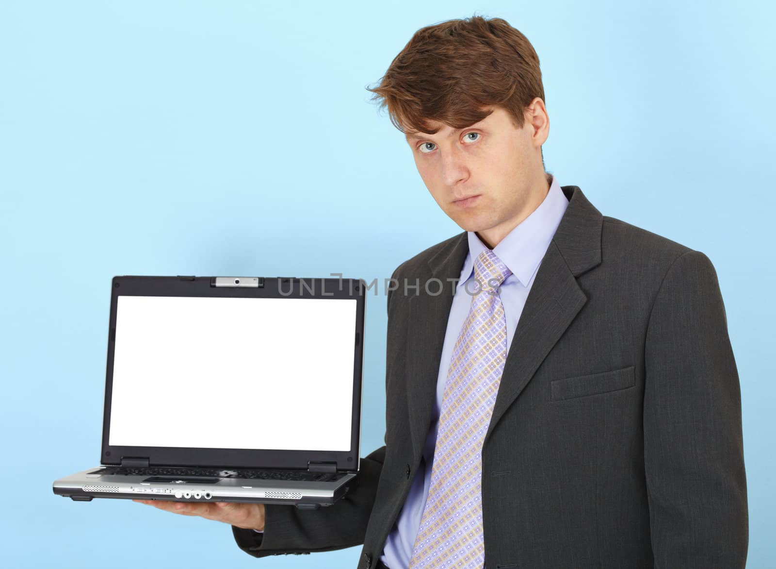 Serious businessman holds on hand laptop by pzaxe