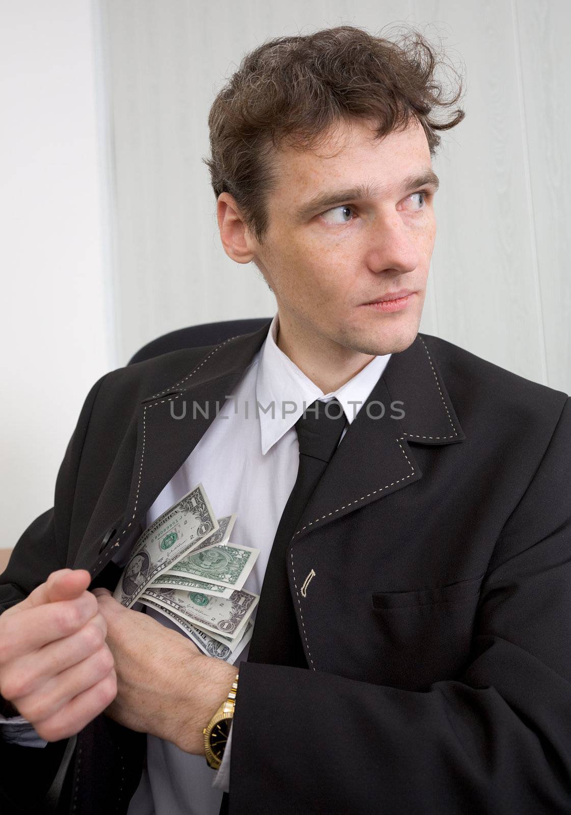 The man in a suit hides money for a bosom, looking around