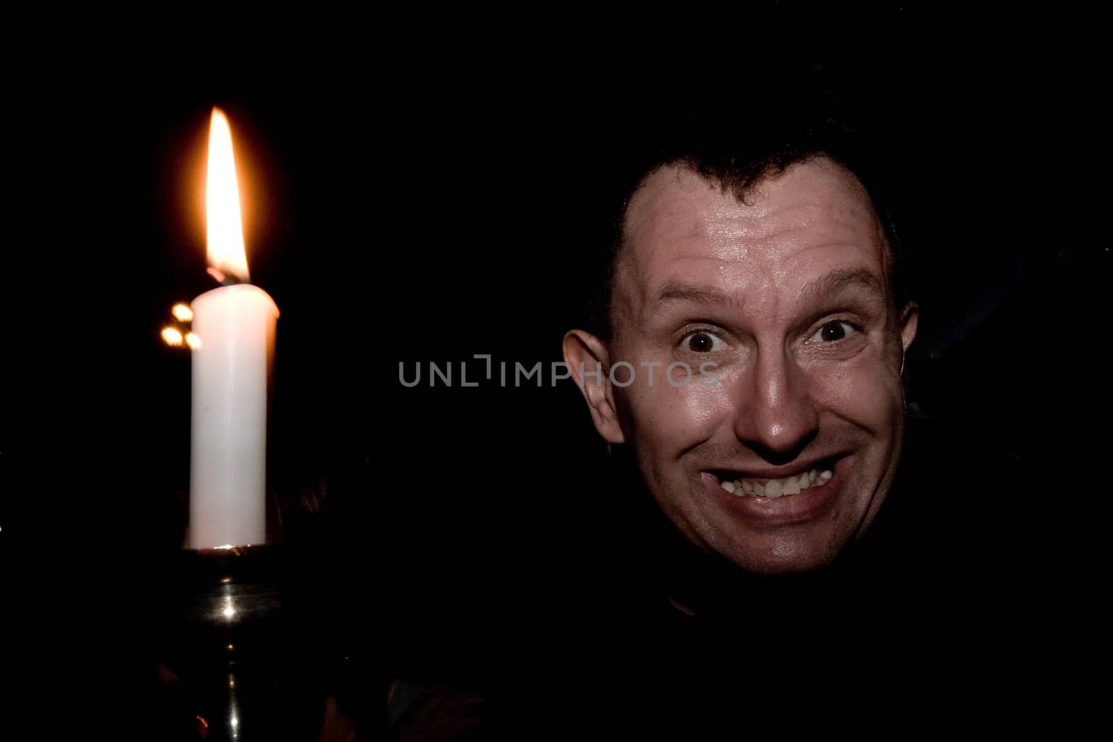 Human face and a candle on black background