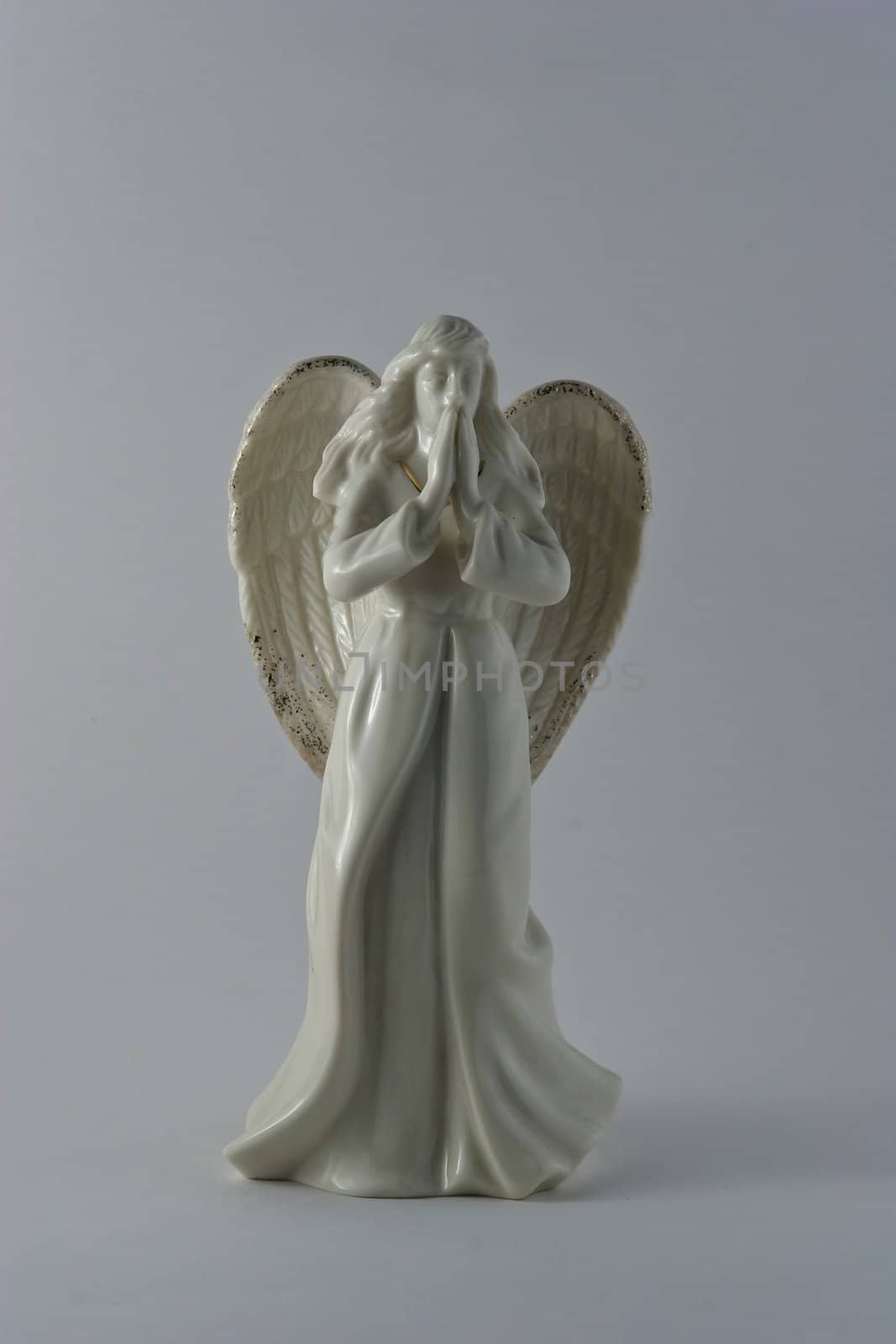 White porcelain angel statuette on white background.
