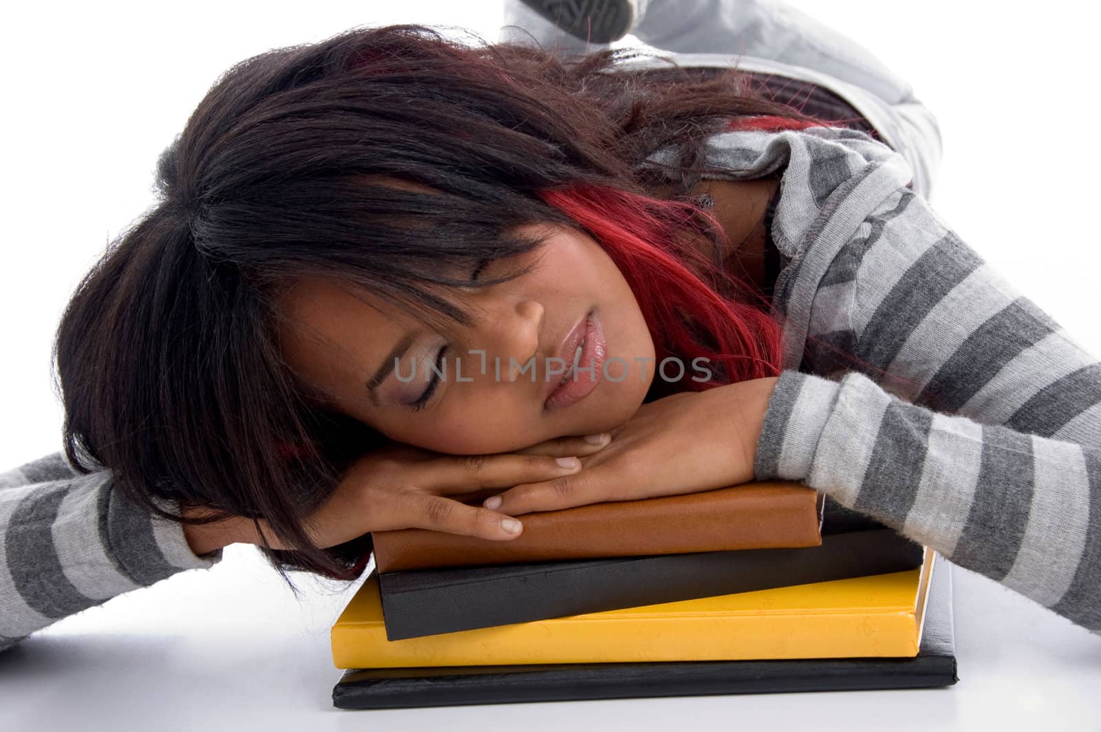 tired school girl sleeping with her books against white background